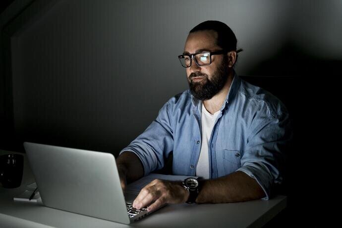 Photo d'une personne travaillant tard sur un ordinateur