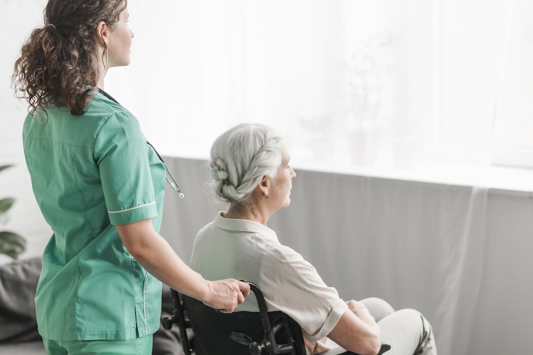 Photo d'une infirmière aidant une personne en chaise roulante