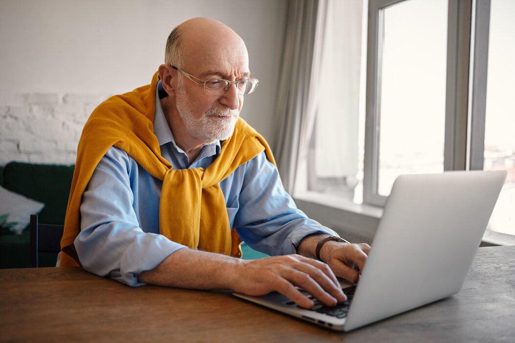 Photo d'une personne âgée sur un pc portable